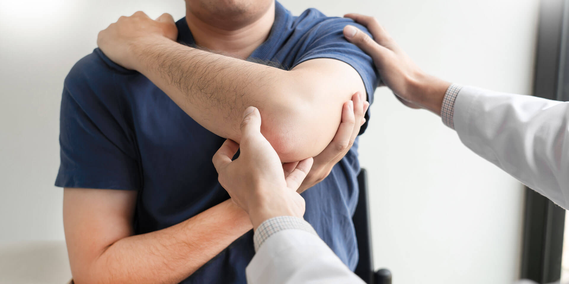 Physiotherapeut behandelt die verletzte Schulter eines Patienten