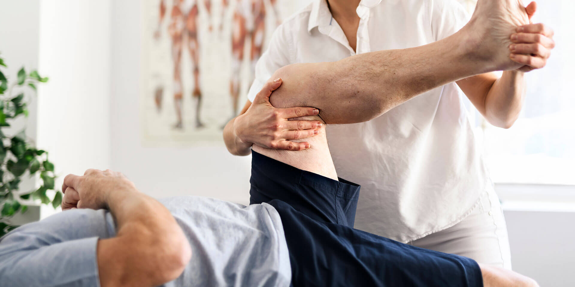 Physiotherapeuten, der das Bein eines Patienten massiert und knetet, sorgt für die medizinische Versorgung der Bänder.