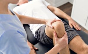 Patient in der Physiotherapie bei Übungen mit seinem Therapeuten