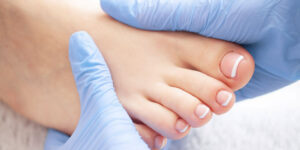 Therapeutin massiert Fuß einer Patientin
