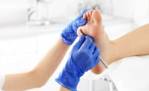 Fußpflegerin entfernt Hornhaut am Fußballen einer Patientin