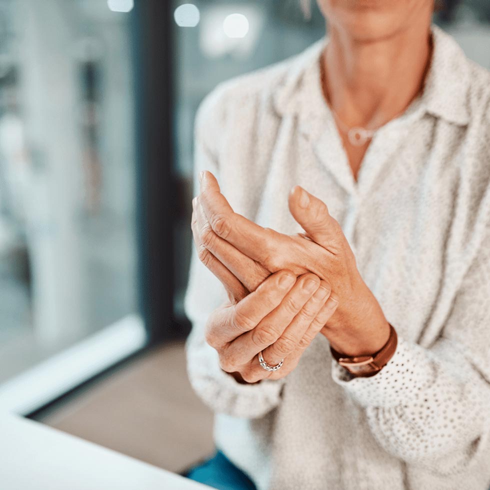 Frau massiert mit einer Hand das andere Handgelenk