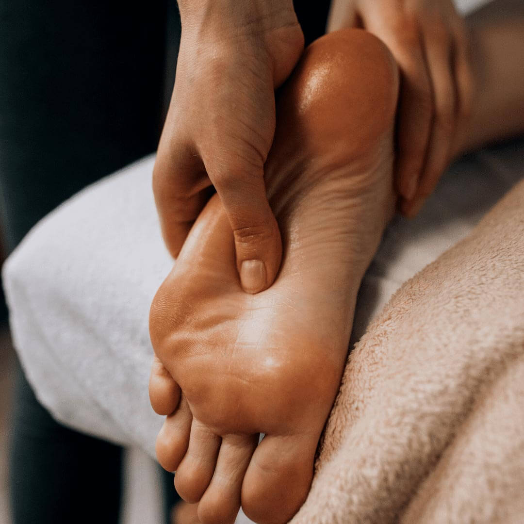 Therapeut massiert Fuß eines Patienten