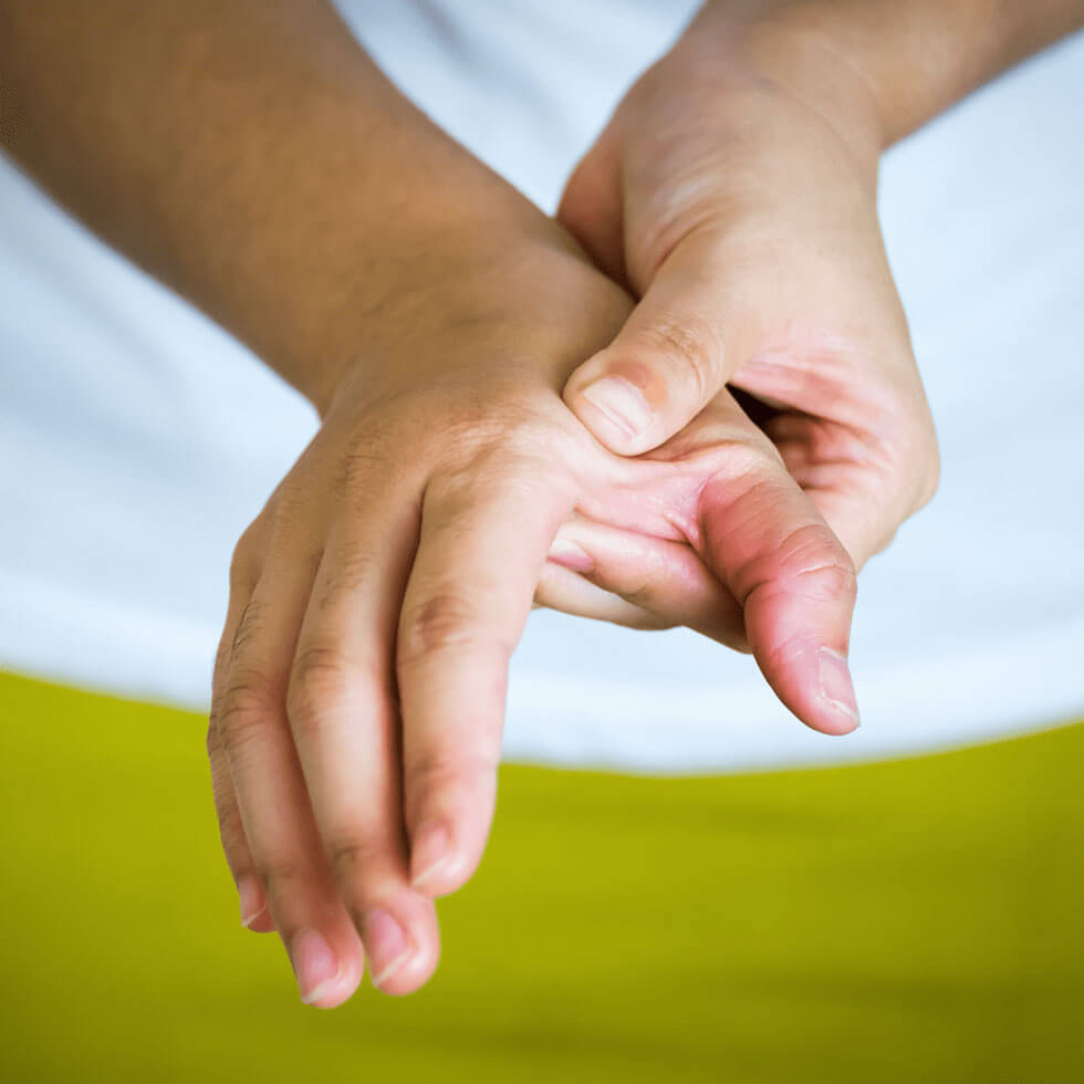 Frau hält sich schmerzende Hand