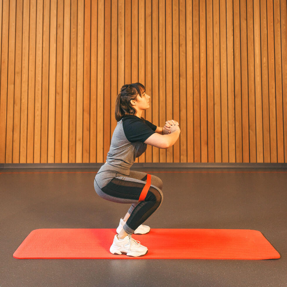 Frau führt Übungen zur Stärkung des Kniegelenks durch